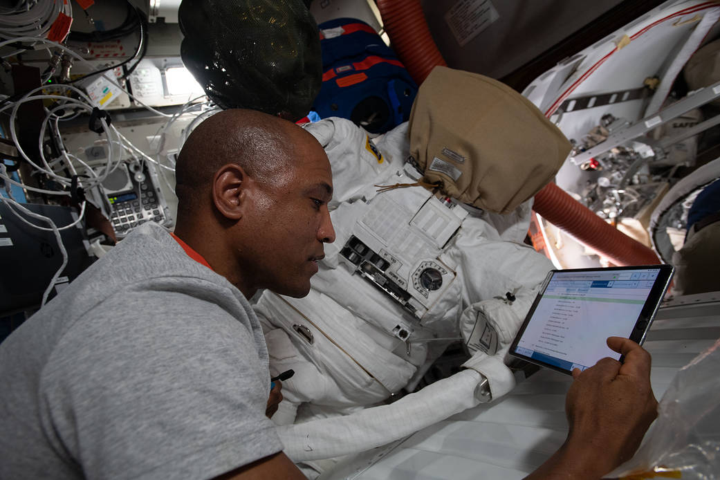 Flight Engineer Victor Glover works on U.S. spacesuit maintenance