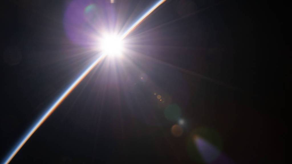 A sunrise breaking through the Earth’s horizon