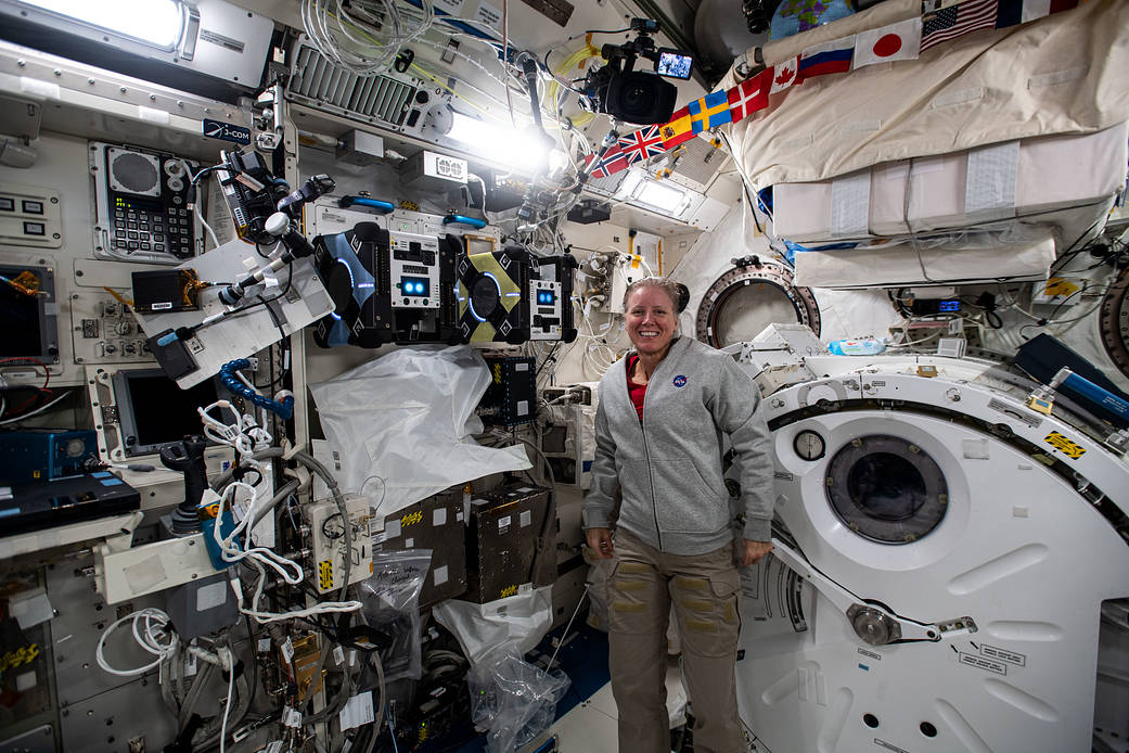 Astronaut Shannon Walker poses with Astrobee robotic assistants