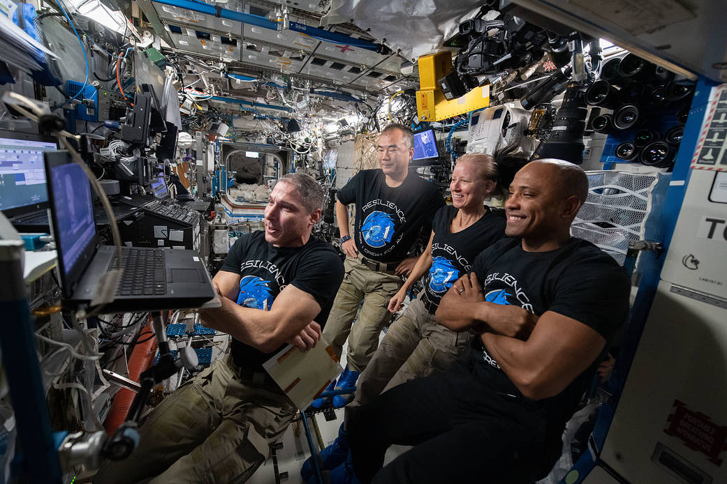 Four Expedition 64 Flight Engineers watch a movie