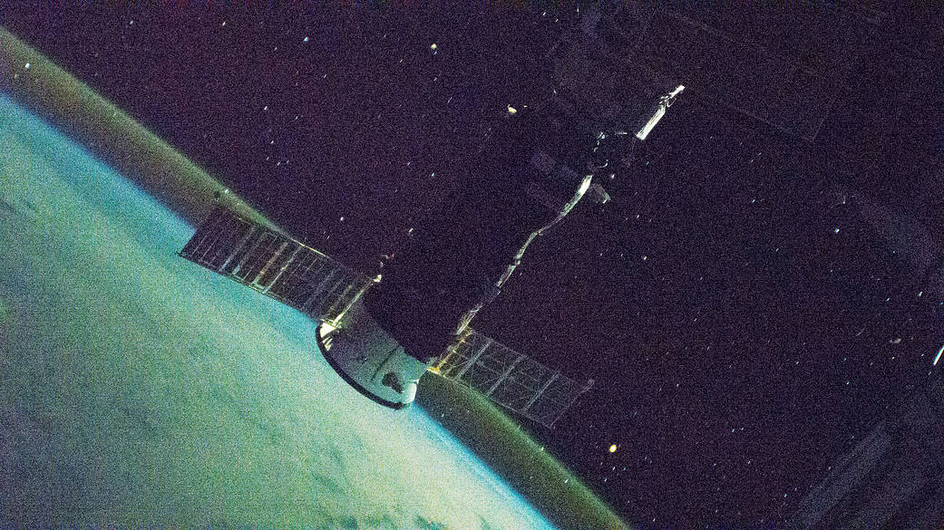 The International Space Station orbits into a sunset