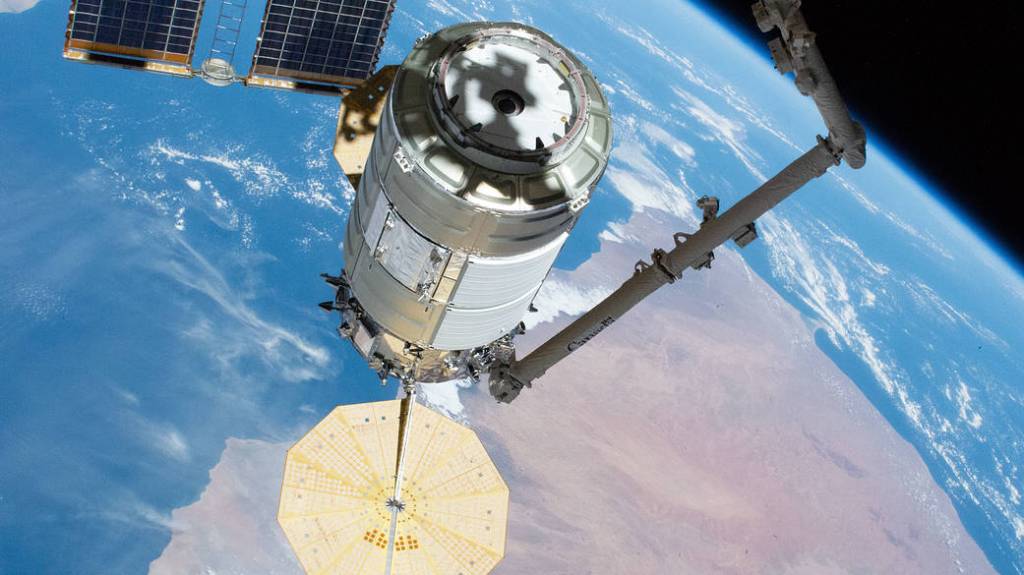 The Cygnus space freighter in the grip of the Canadarm2 robotic arm