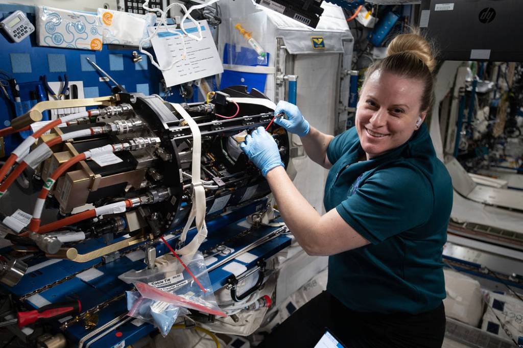 Astronaut Kate Rubins works on combustion science gear
