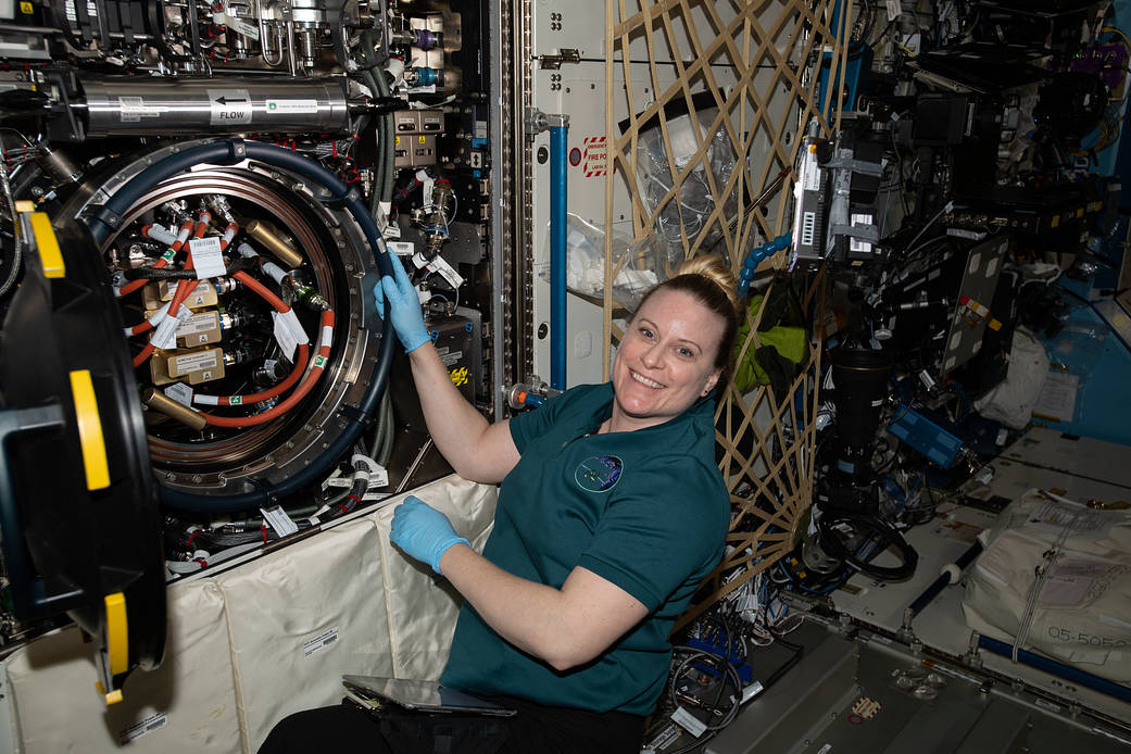 Astronaut Kate Rubins works on combustion science gear