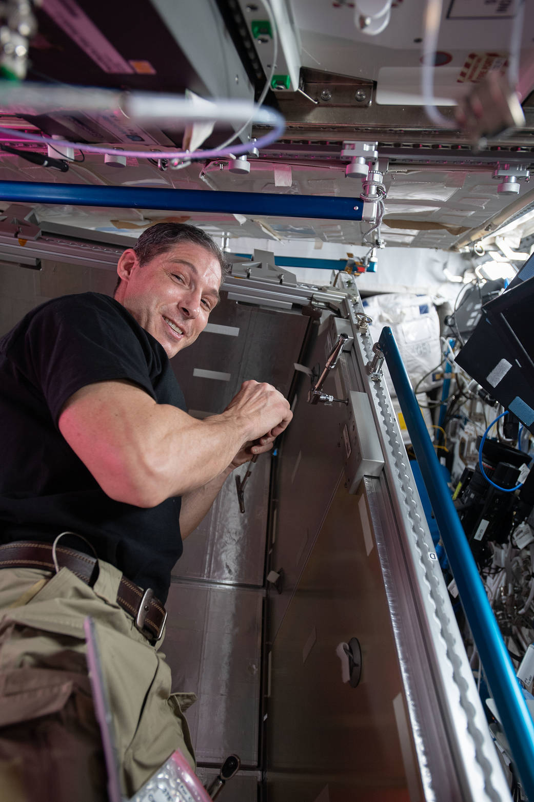 NASA astronaut Michael Hopkins installs temporary sleeping quarters