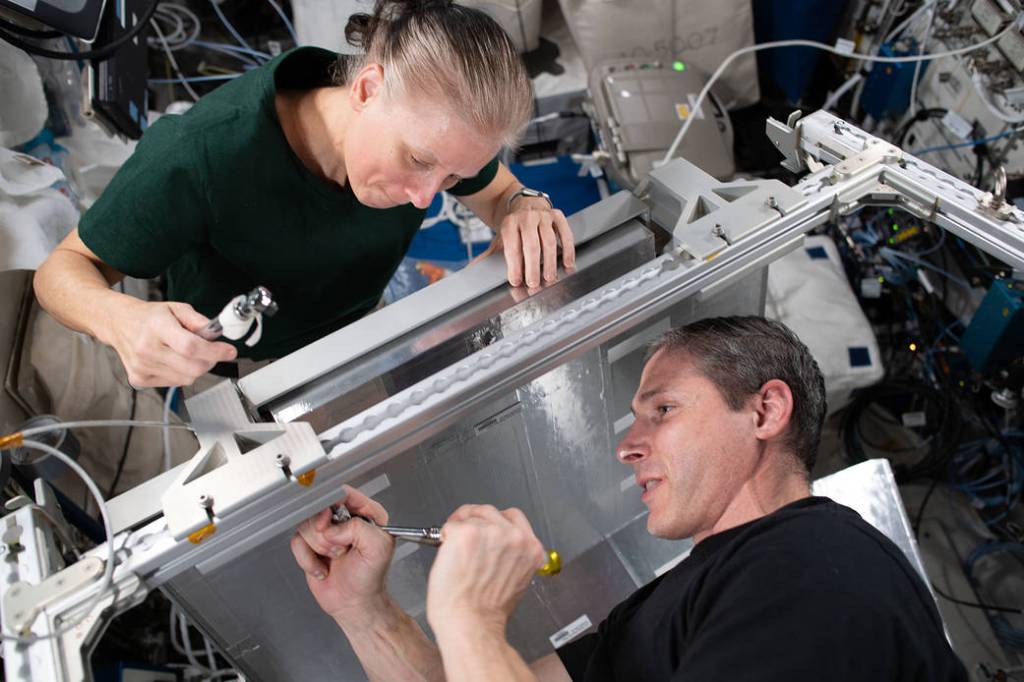 Astronauts Shannon Walker and Michael Hopkins install sleeping quarters