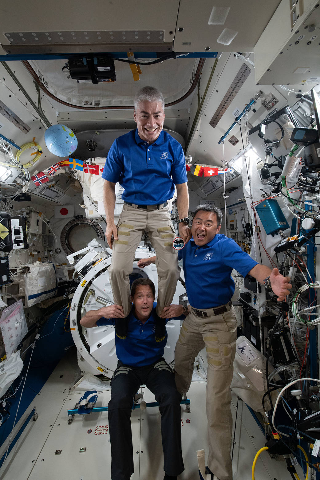Three Expedition 65 crewmates pose for a playful picture
