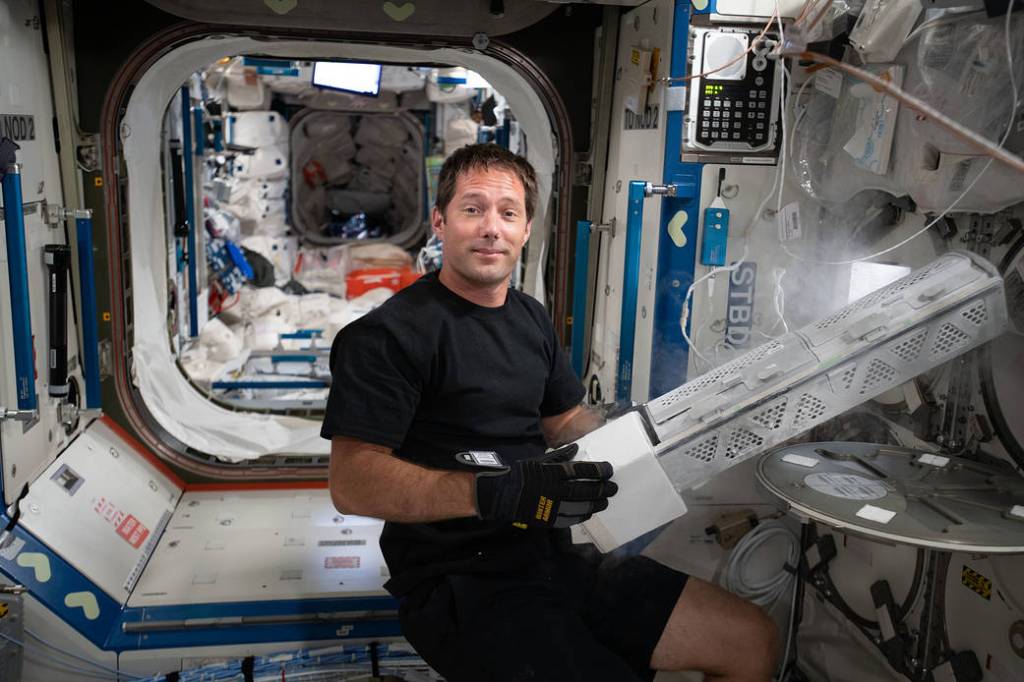 Astronaut Thomas Pesquet transfers samples to a science freezer