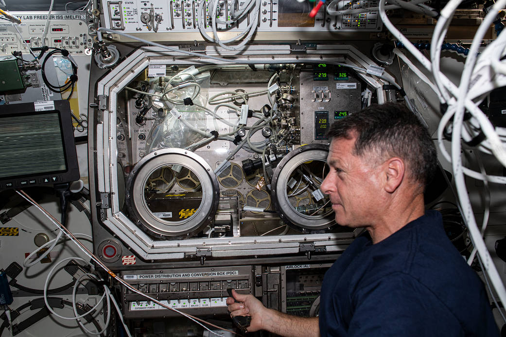 Astronaut Shane Kimbrough sets up hardware for a physics study