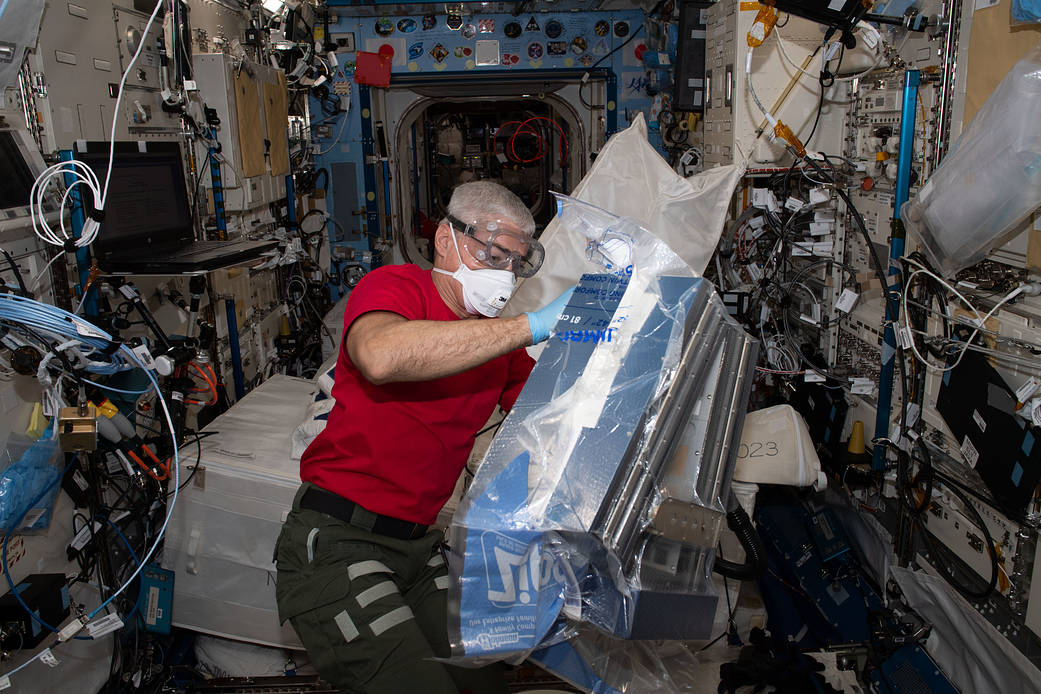 NASA astronaut Mark Vande Hei unpacks research hardware