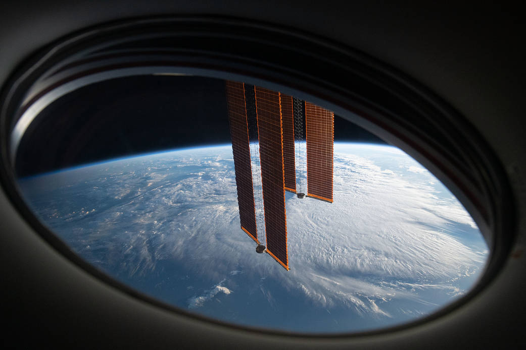 The station's solar arrays drape across the Earth's horizon