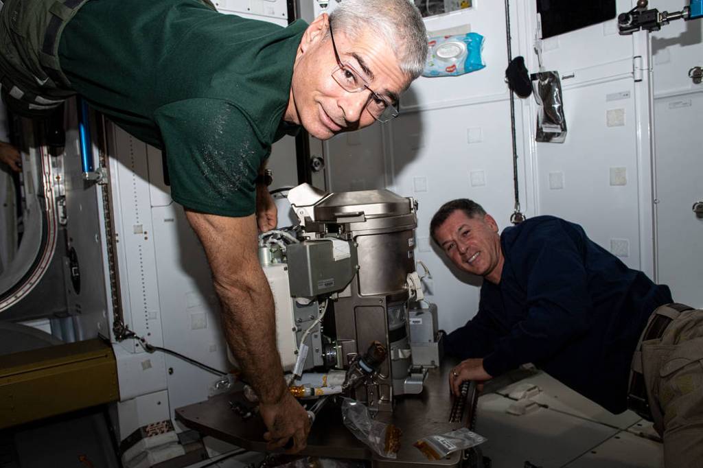 Astronauts Mark Vande Hei and Shane Kimbrough work on a new toilet