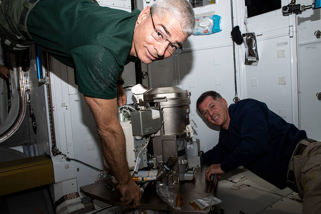 Astronauts Mark Vande Hei and Shane Kimbrough work on a new toilet