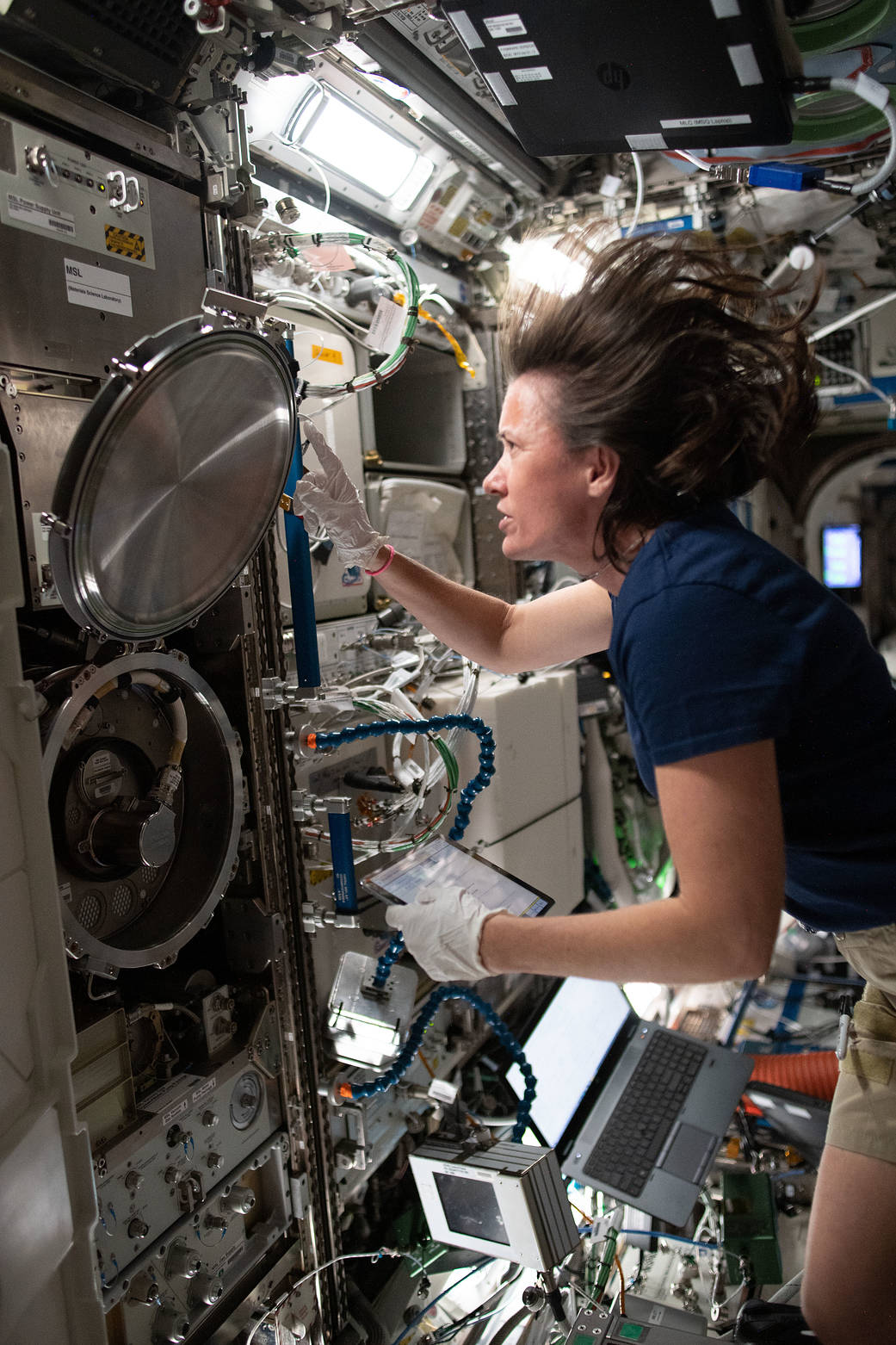 Astronaut Megan McArthur swaps sample cartridges in a research rack