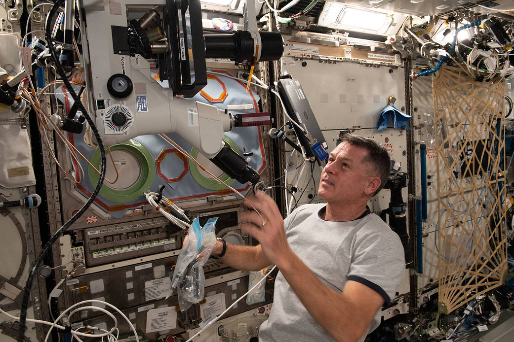 Astronaut Shane Kimbrough sets up a microscope