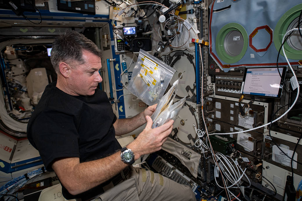 Astronaut Shane Kimbrough checks out sample packs for a biology study
