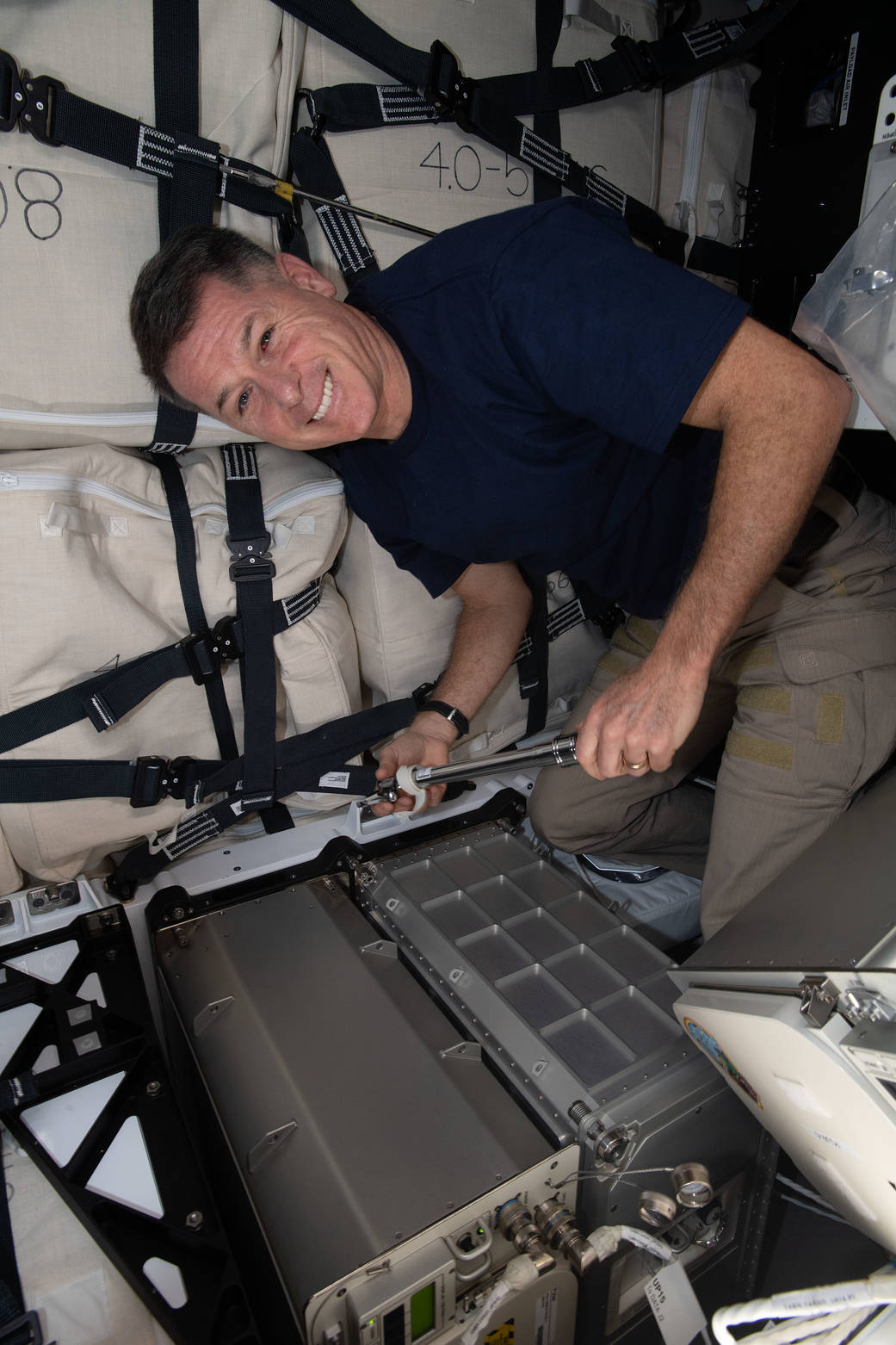 Astronaut Shane Kimbrough loads a science freezer inside Cargo Dragon