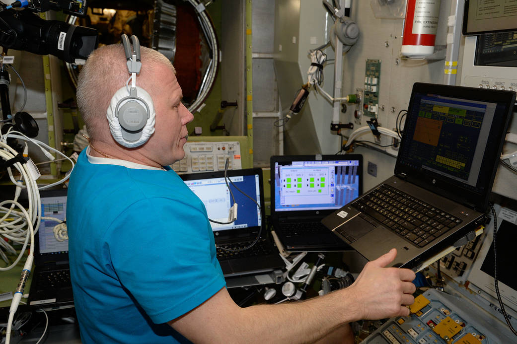 Cosmonaut Oleg Novitskiy practices an emergency drill on a computer