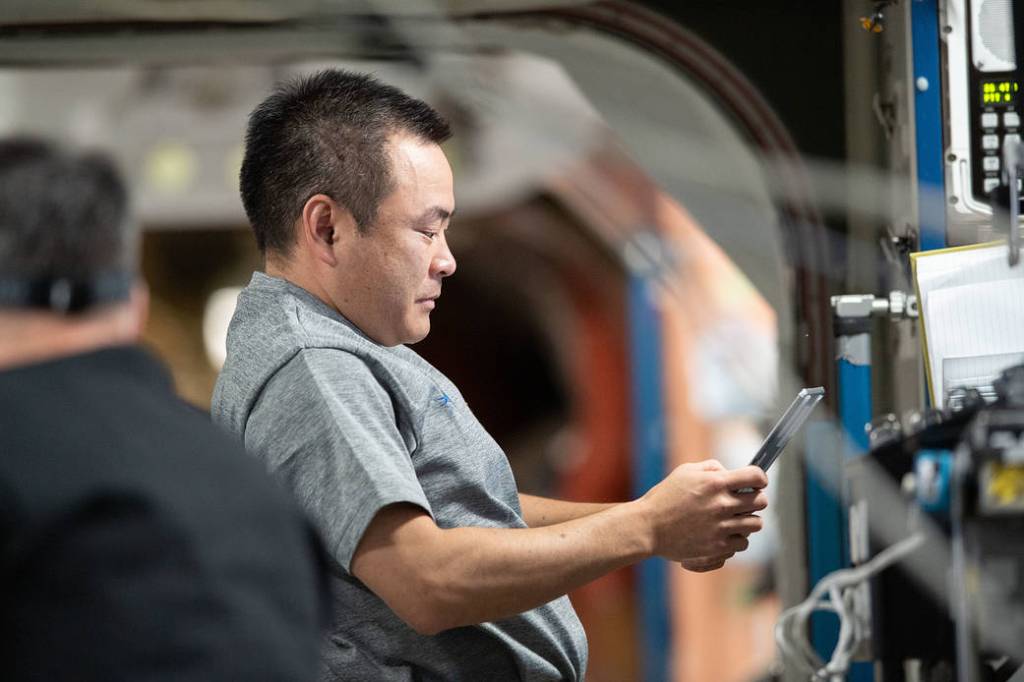 Astronaut Akihiko Hoshide reviews procedures on a computer tablet