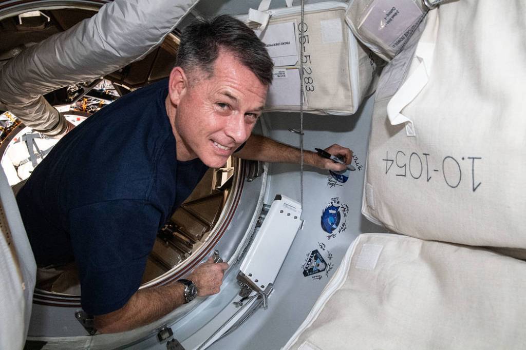 Astronaut Shane Kimbrough signs his name next to a mission sticker