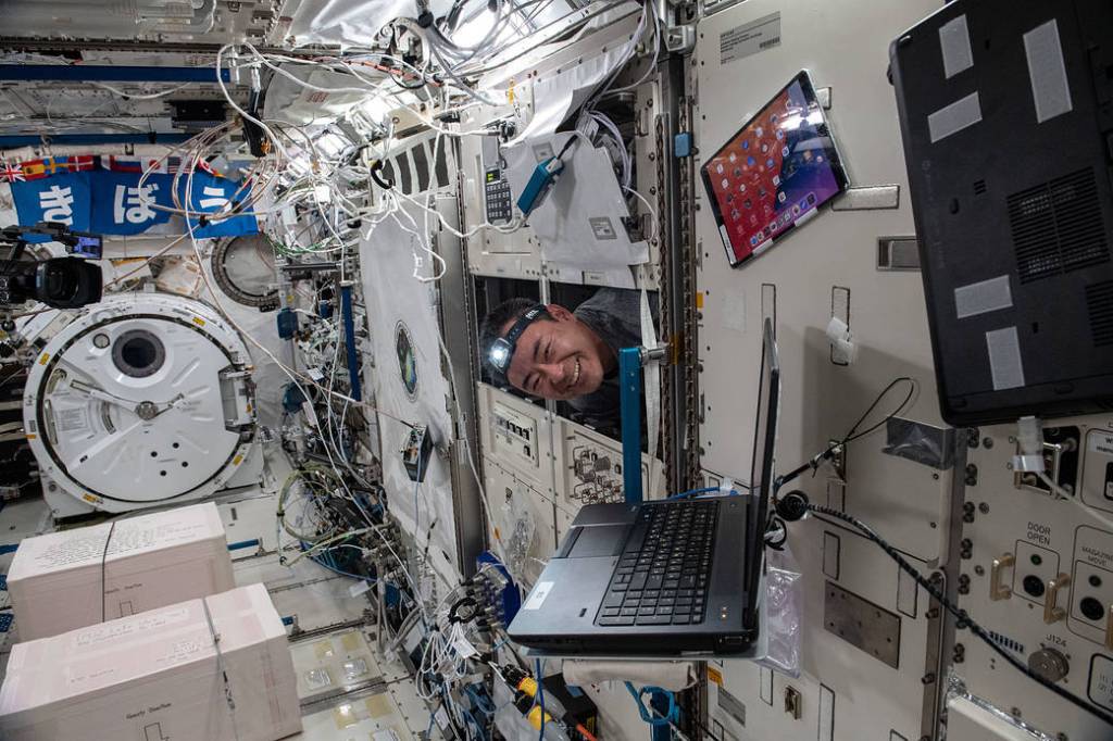 Astronaut Akihiko Hoshide pokes his head out from behind racks