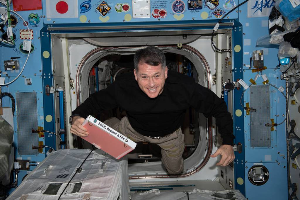 Astronaut Shane Kimbrough carries an emergency manual