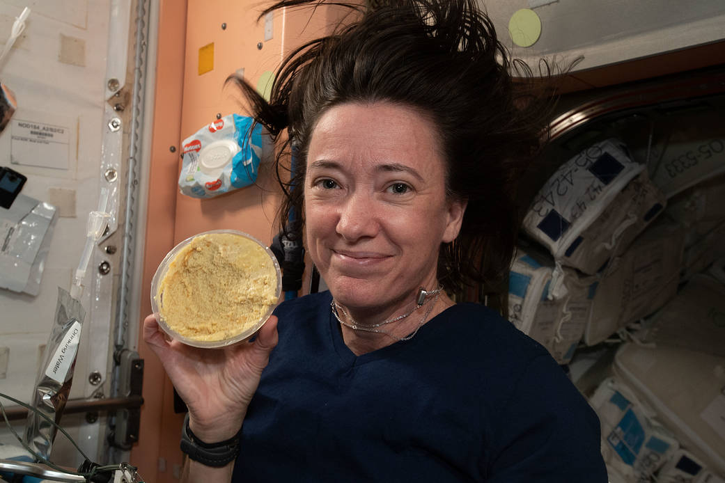 Astronaut Flight Engineer Megan McArthur shows off a container of hummus