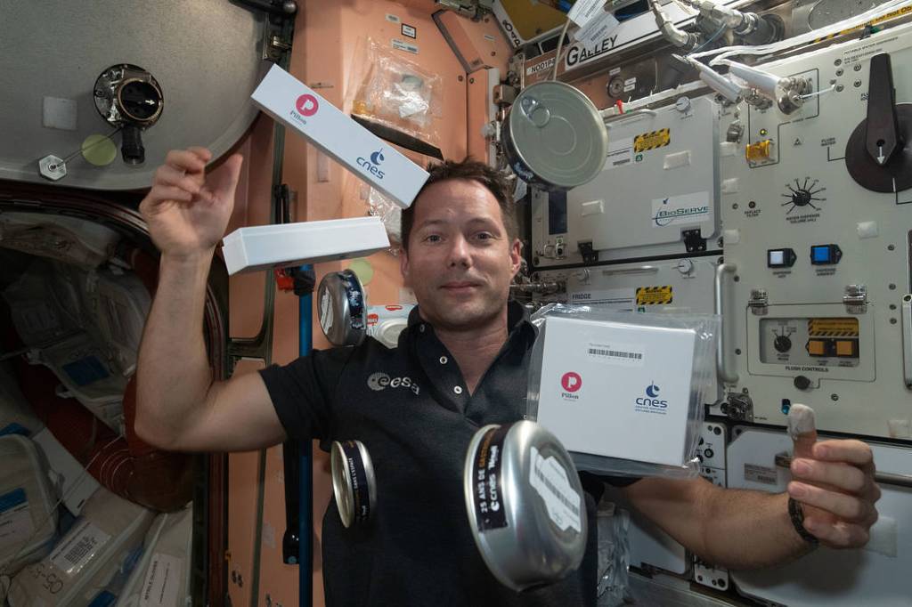 Astronaut Thomas Pesquet seemingly juggles food and snack containers