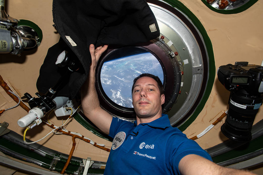 Astronaut Thomas Pesquet is photographed in front of a station window
