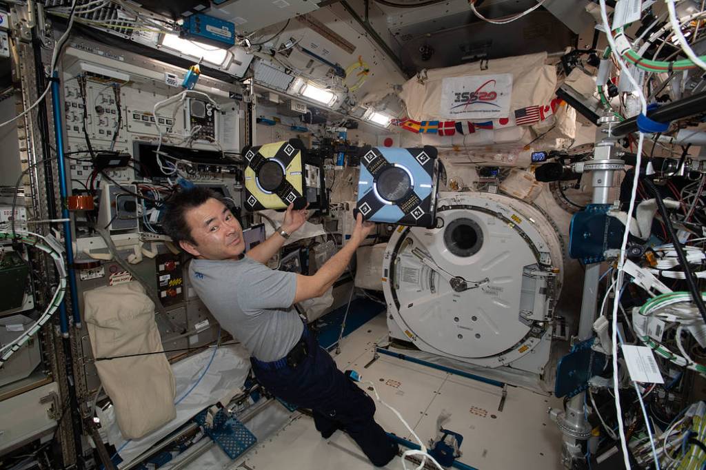 Astronaut Akihiko Hoshide checks out Astrobee robotic free-flyers