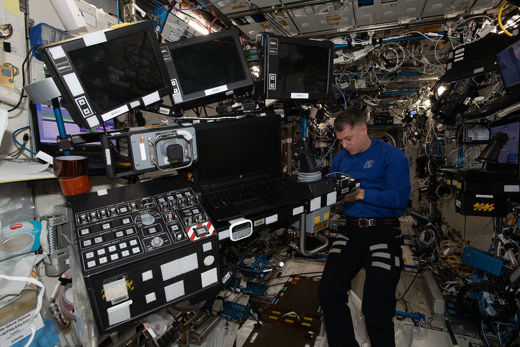 Astronaut Shane Kimbrough removes robotics workstation components
