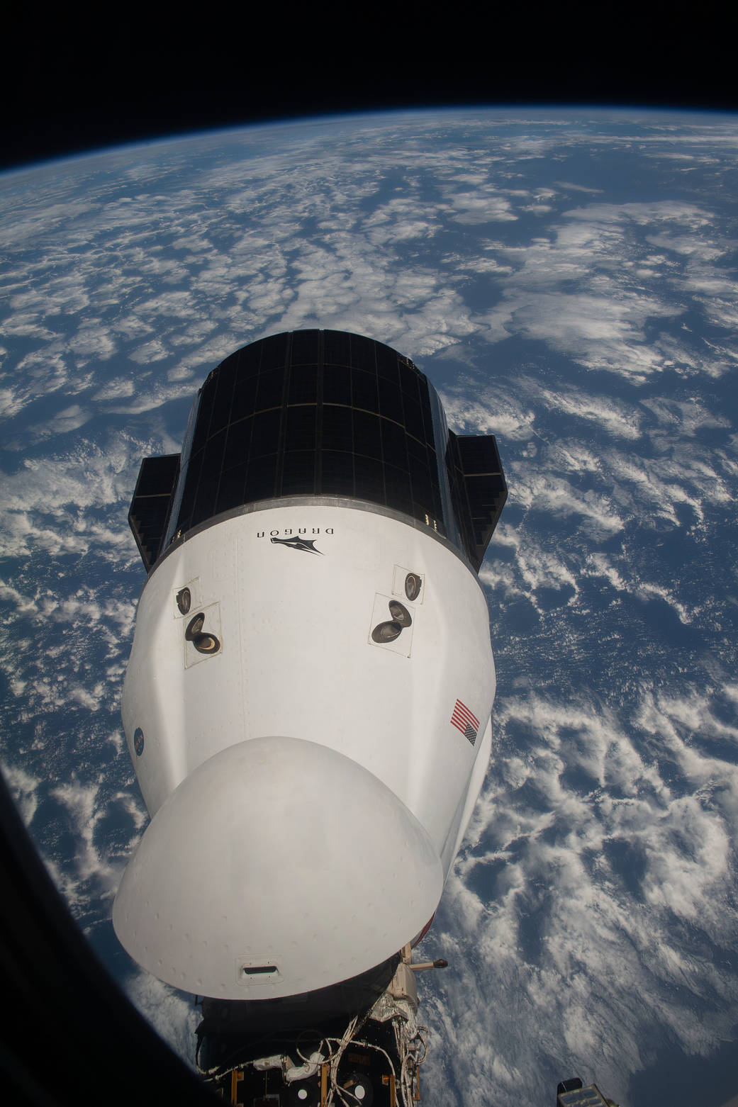 The SpaceX Cargo Dragon resupply ship is pictured from a window on the SpaceX Crew Dragon spacecraft.