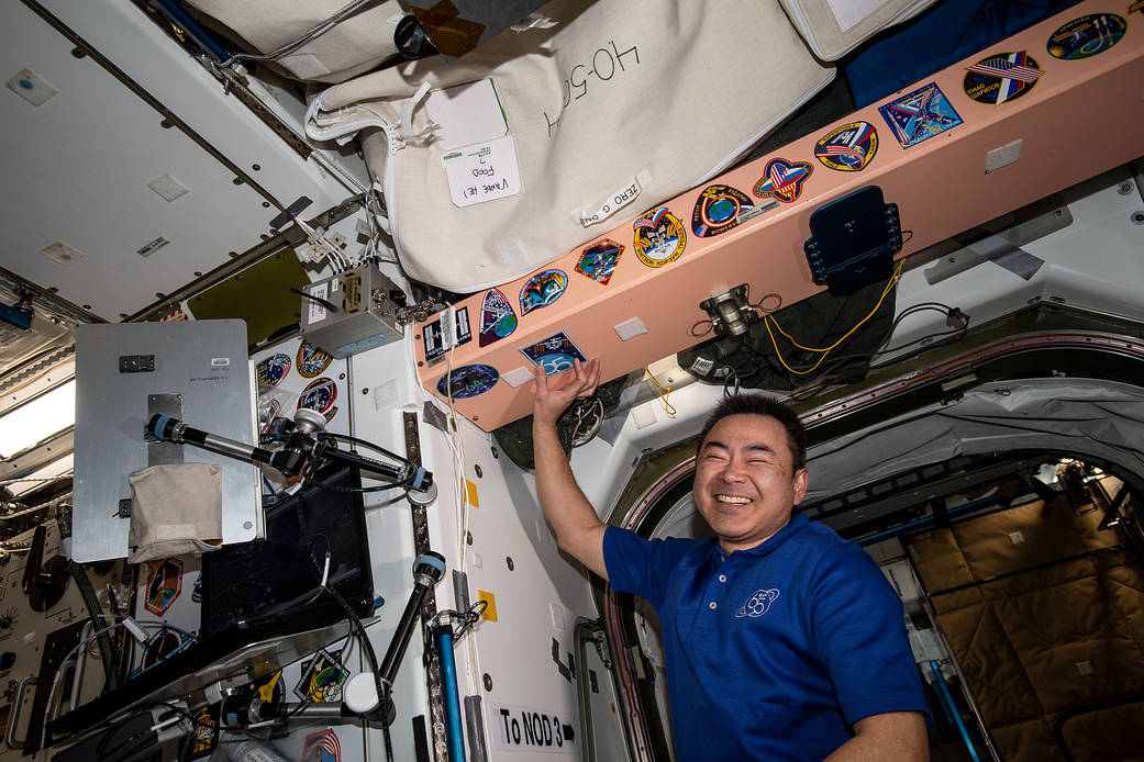 Akihiko Hoshide points to his mission's insignia sticker