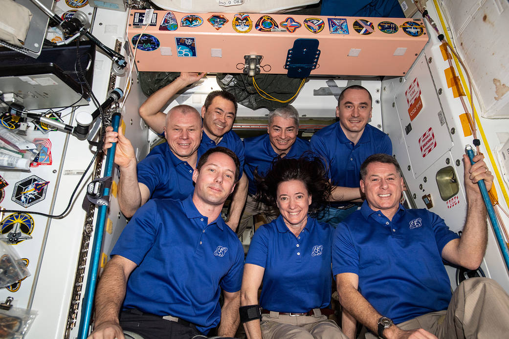 The seven-member Expedition 65 crew gathers for a portrait