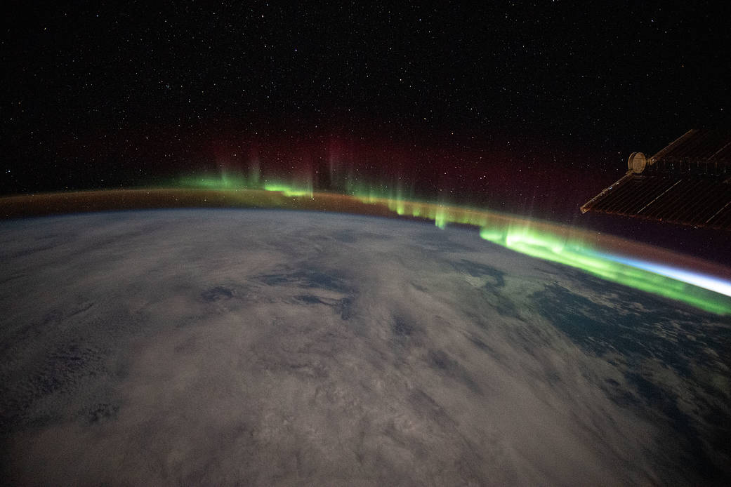 An aurora streams over the Earth
