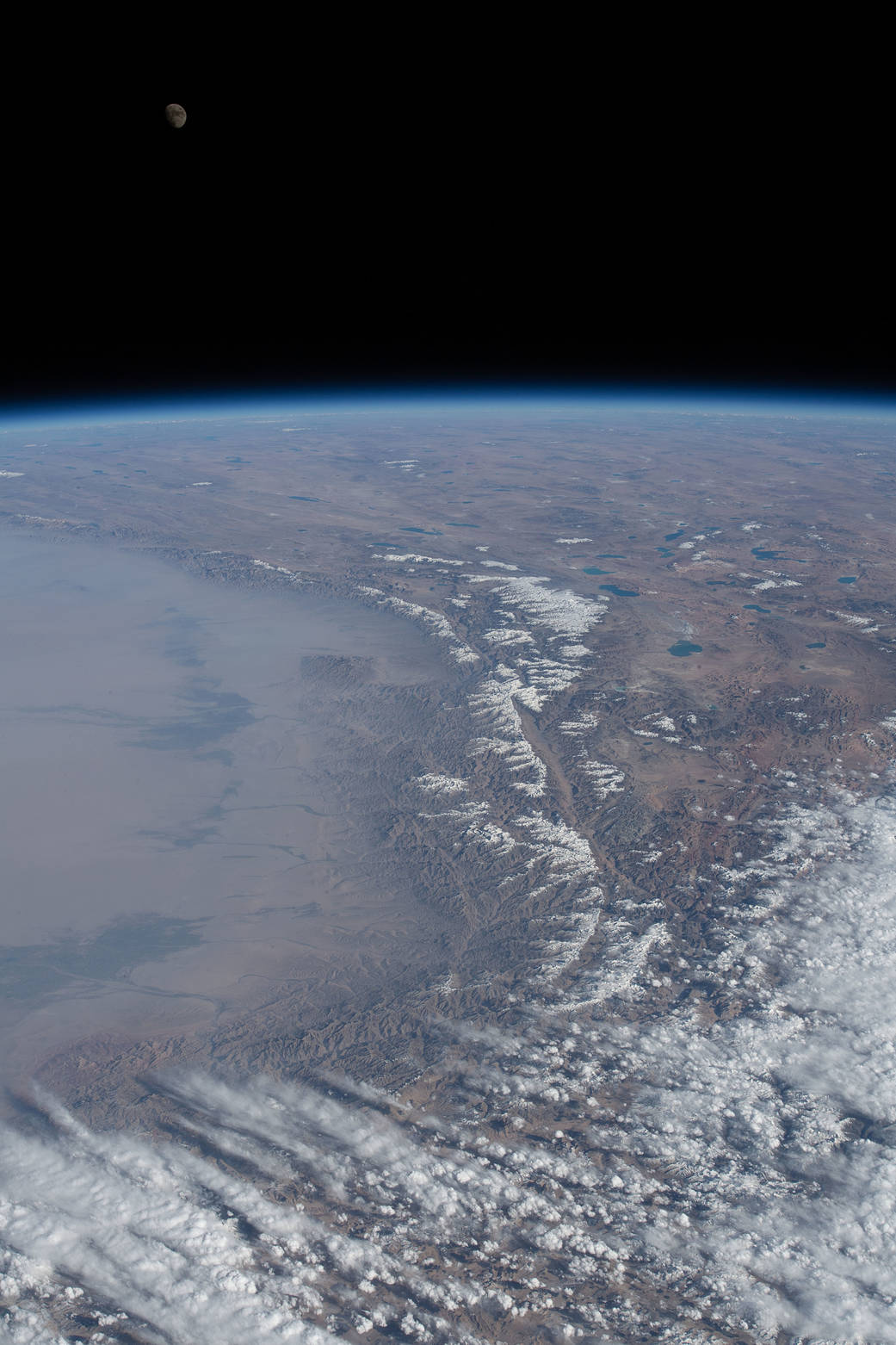 The waxing gibbous Moon over Earth's horizon