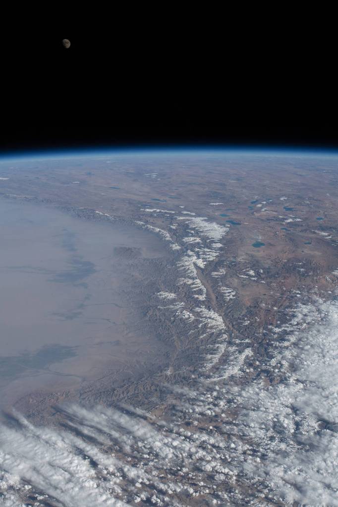 The waxing gibbous Moon over Earth’s horizon