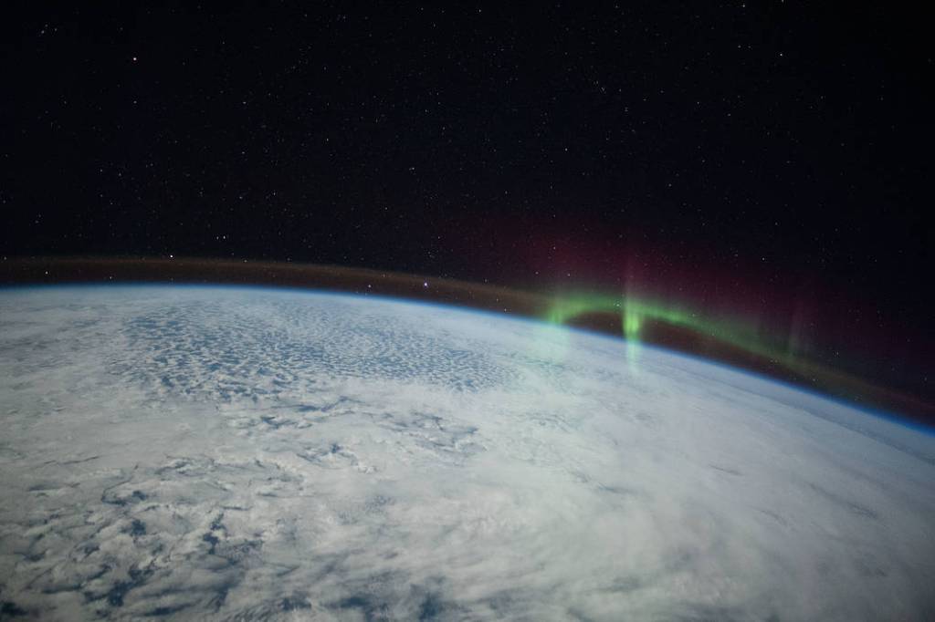 A wispy aurora intersects with Earth’s airglow