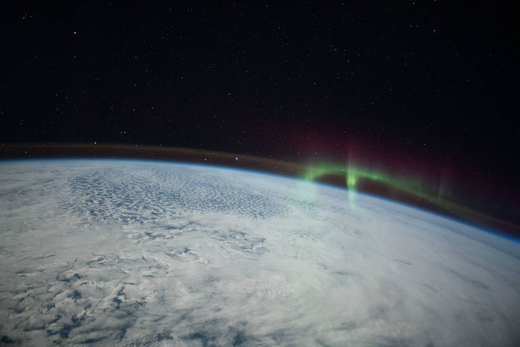 A wispy aurora intersects with Earth's airglow