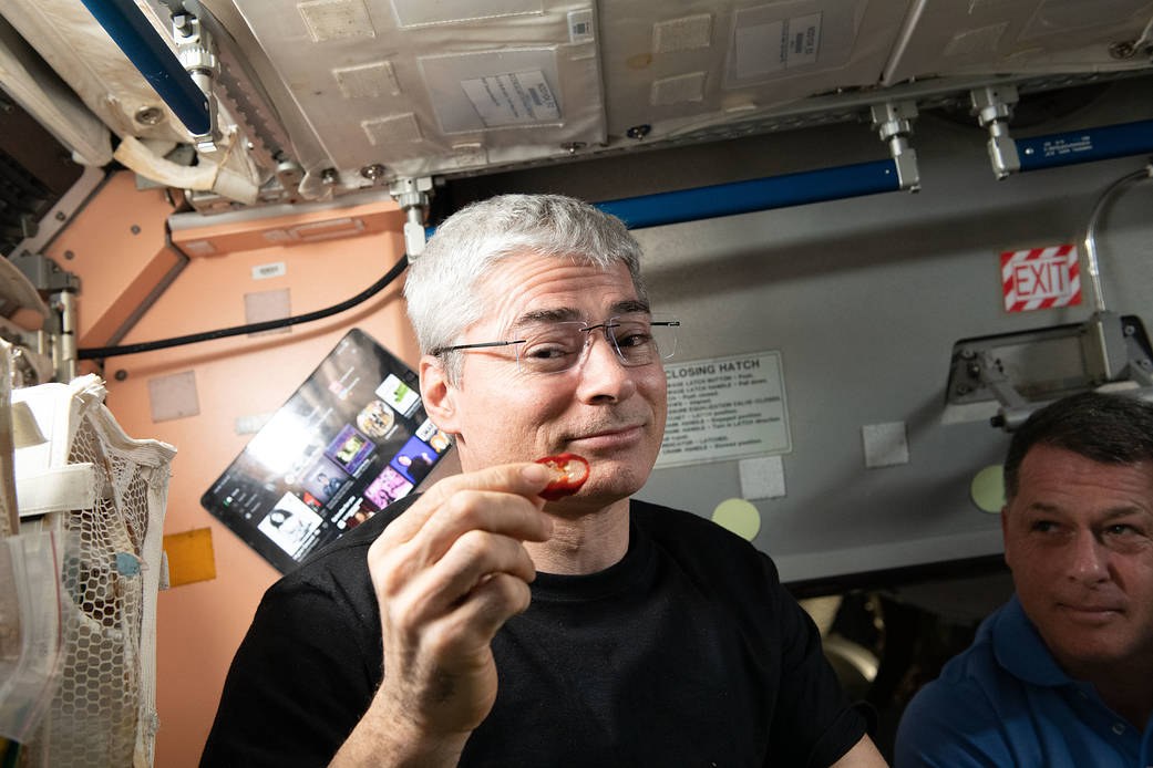 Astronaut Mark Vande Hei samples a space-grown red chile pepper