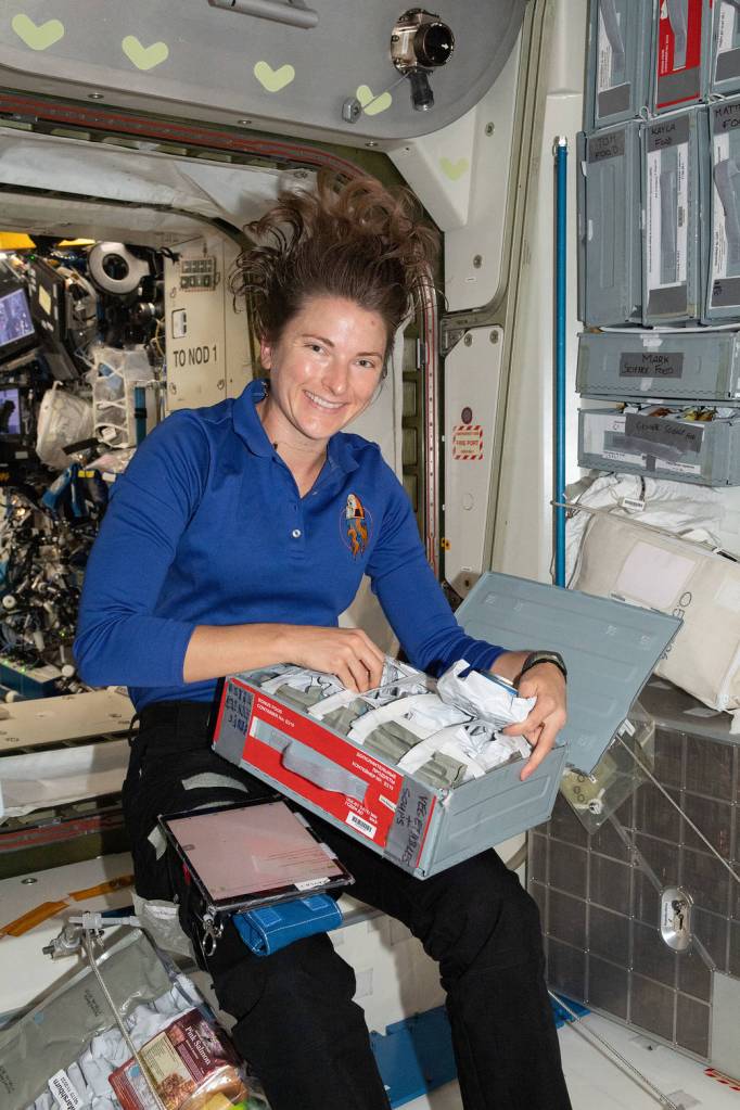 Astronaut Kayla Barron chooses a food pouch for lunch