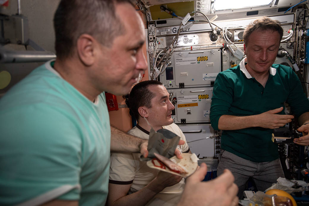 Expedition 66 crew members gather for a Thanksgiving meal