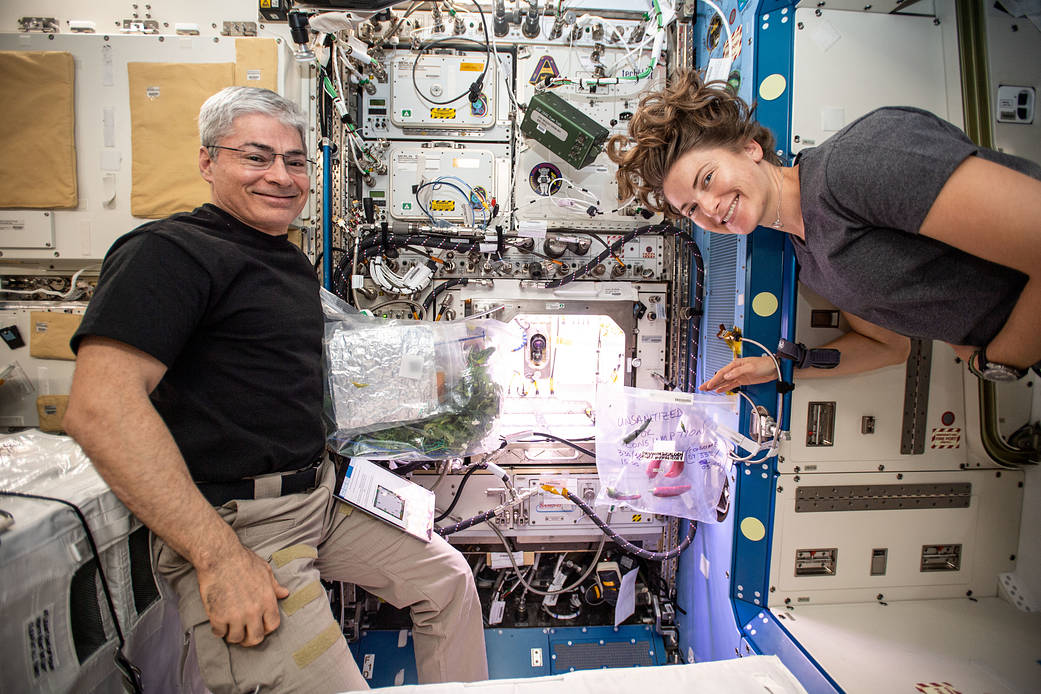Astronauts Mark Vande Hei and Kayla Barron in front of the Advanced Plant Habitat