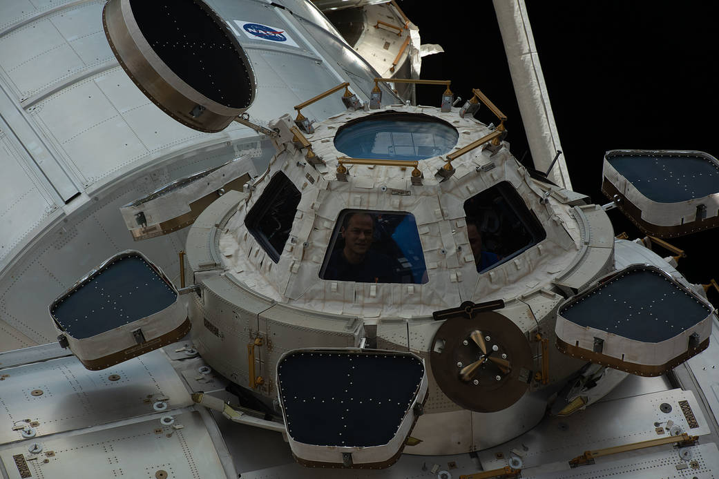 Astronaut Thomas Marshburn peers out from a window inside the cupola