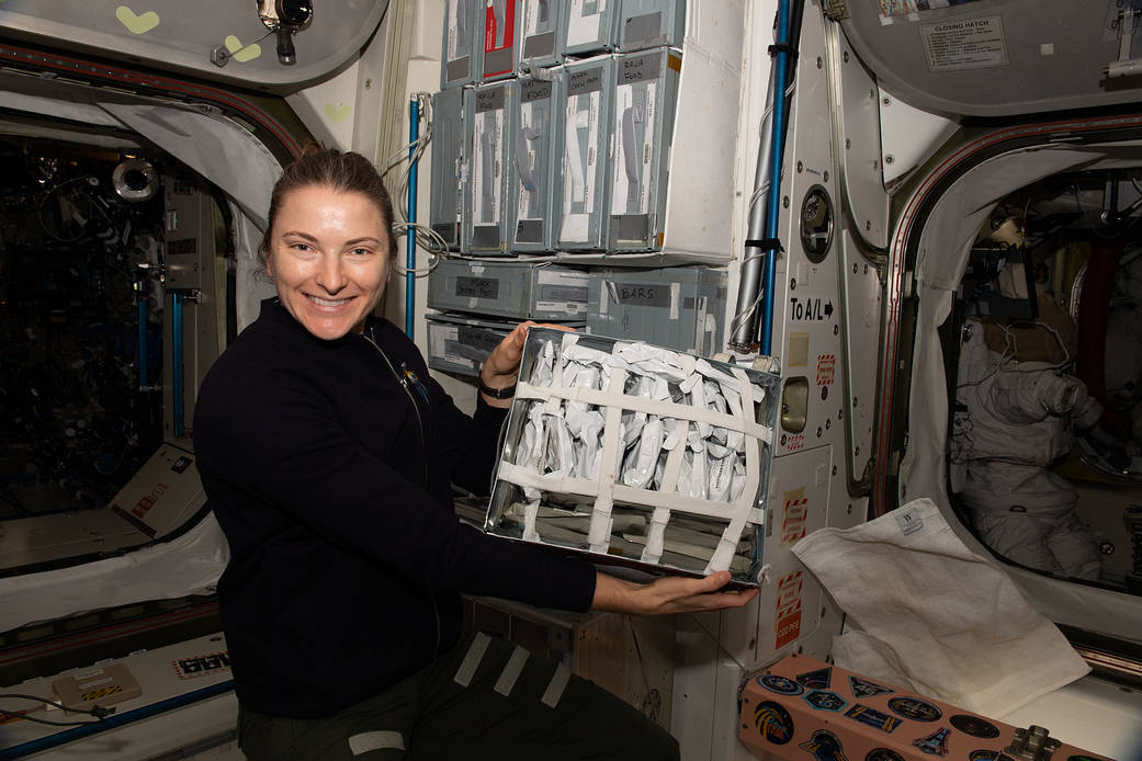 Astronaut Kayla Barron shows off food packets