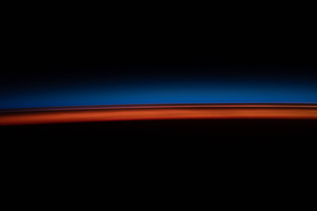 The first rays of an orbital sunrise illuminate Earth's atmosphere