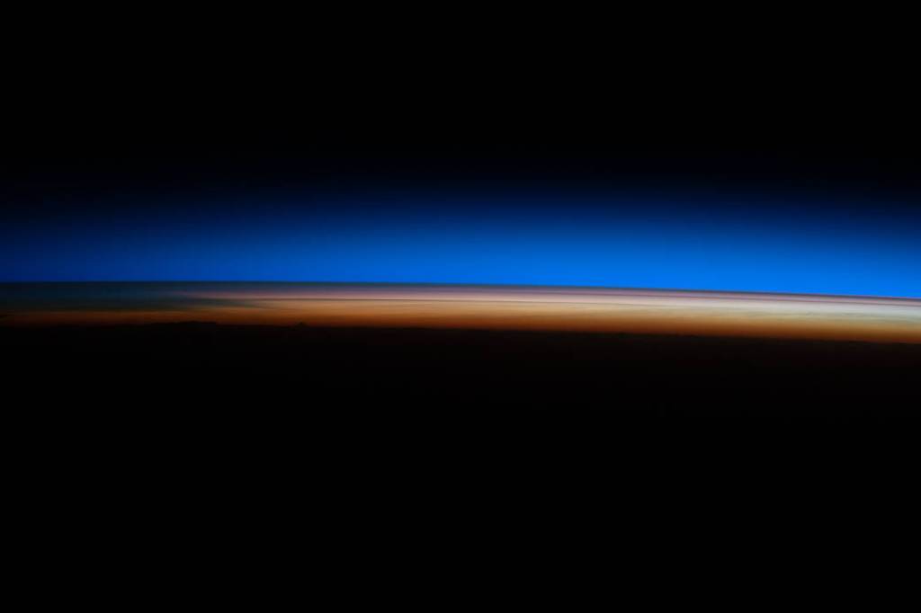 The first rays of an orbital sunrise illuminate Earth’s atmosphere