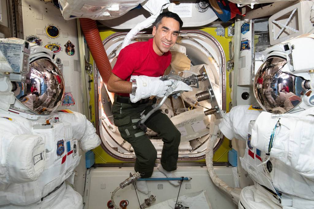 Astronaut Raja Chari tests using tools while wearing a spacesuit glove