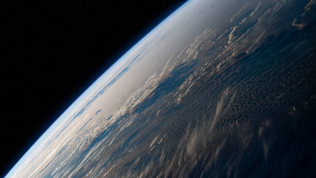 The station orbits above a cloudy Pacific Ocean