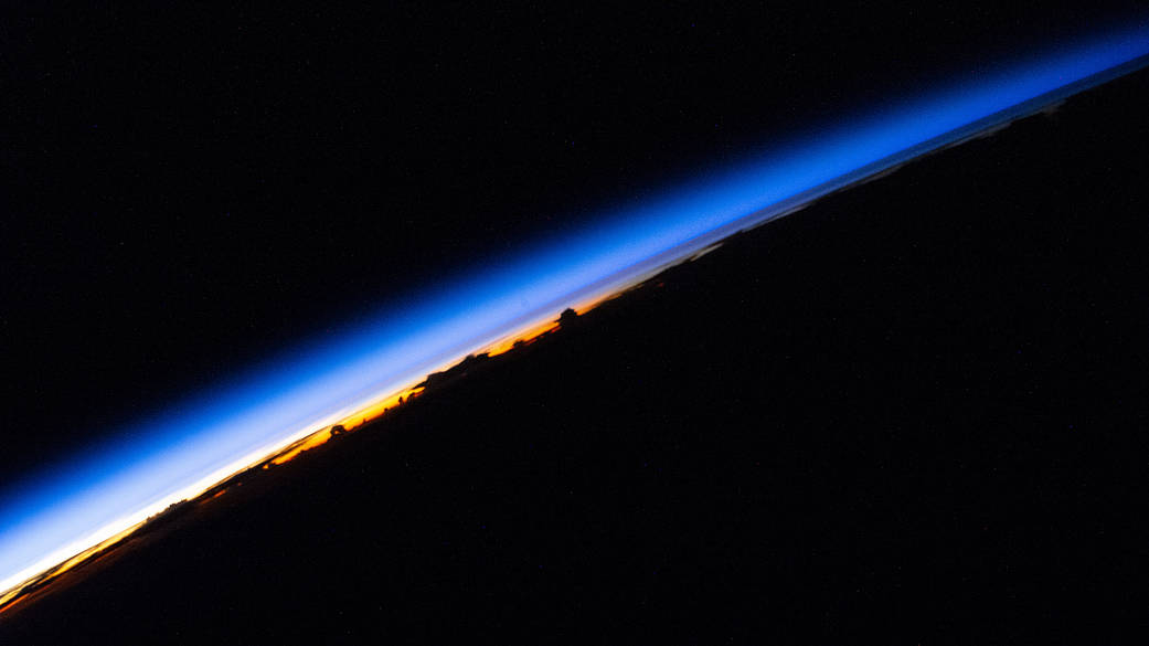 An orbital sunrise beams across Earth's horizon